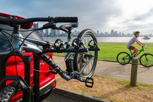 Lockable Tow Bar Bike Rack Four Bicycle Carrier With Biker Riding Past